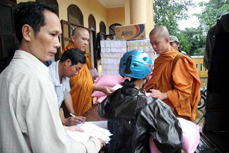 Sư Chơn Hữu (bên phải) trong một lần trao quà cứu trợ đồng bào bão lụt tại Huế.