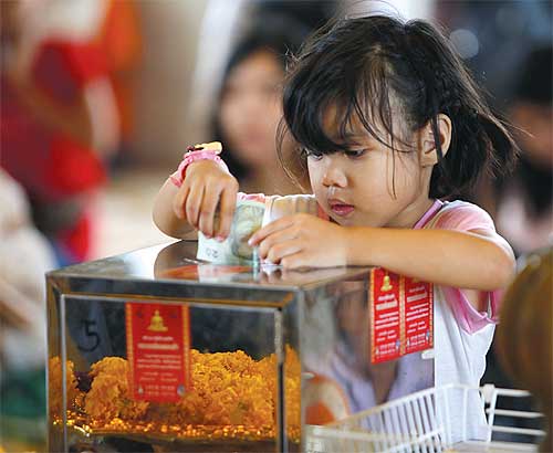 Cô bé cúng d__ng trong hòm công __c t_i chùa Traimitr Withayaram (Bangkok).jpg