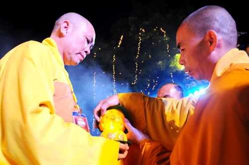 Mở màn đêm hội, thầy Trưởng ban tổ chức đón nhật ánh sáng từ bàn thờ Phật.