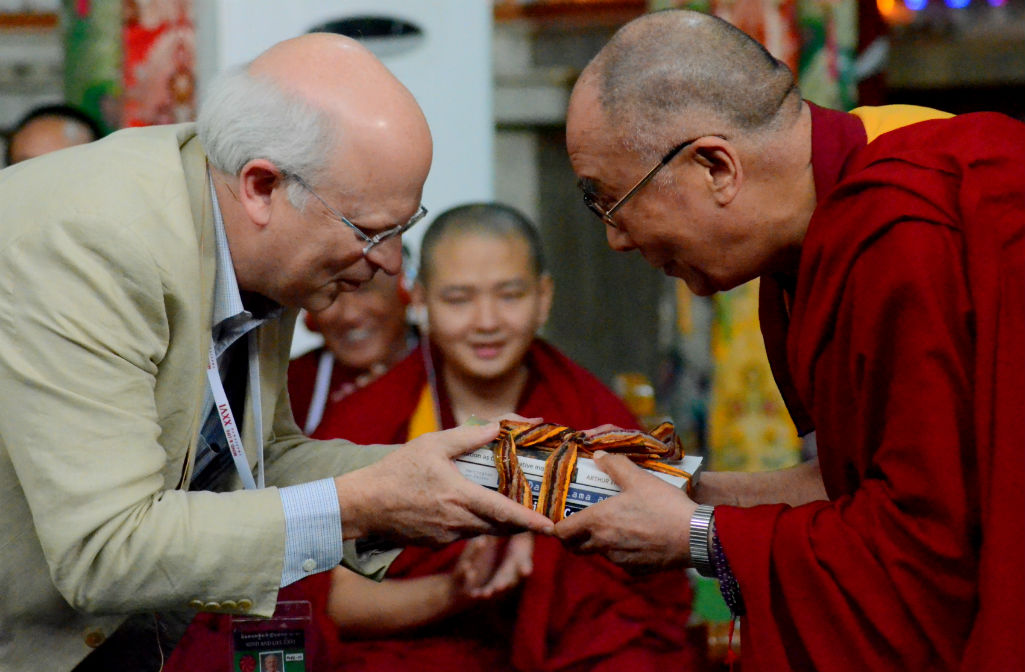Arthur Zajonc, President of the Mind & Life Institute, presents His Holiness the Dalai Lama with a well packed box of books at the end of the Mind and Life XXVI Conference at Drepung Monastery in Mundgod, India, on January 22, 2013. Photo: TPI/Yeshe Choesang mind-life-2013-buddhism-science-1